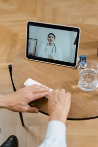 Elderly patient in video call with doctor using tablet. Healthcare technology concept.